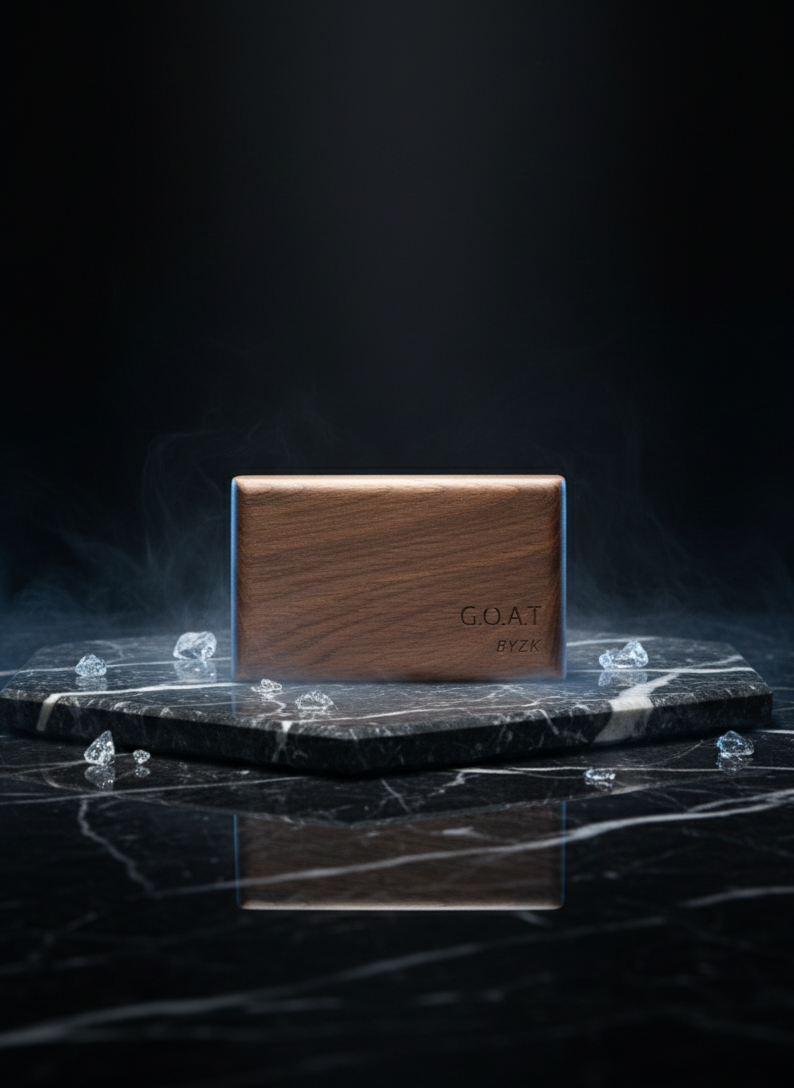 G.O.A.T BYZK Black Ice air freshener displayed on black marble with scattered ice crystals, premium walnut design, luxury product photo.